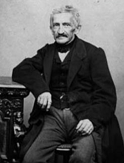 B&W photograph of Leupold von Lwenthal sitting, with his right arm resting on a table or cupboard
